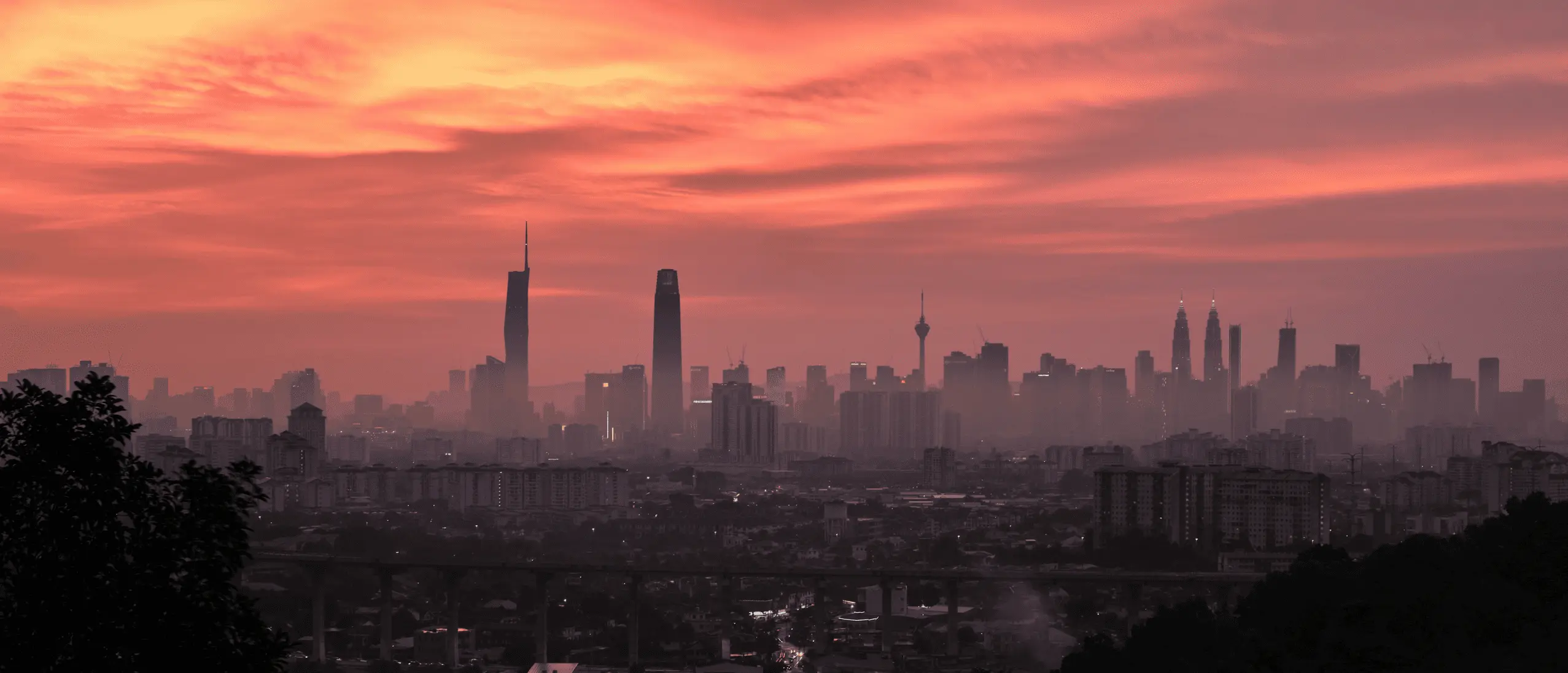 Kuala Lumpur skyline with transit light trails at night.